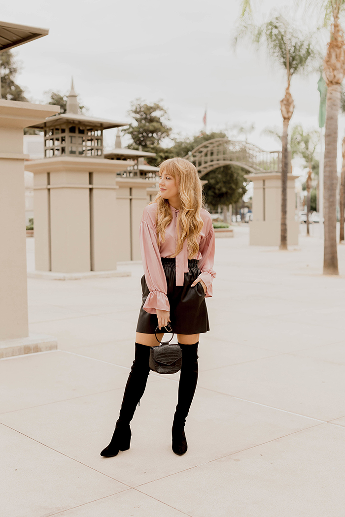 pink everly blouse, light pink everly blouse, faux leather skirt, black over the knee boots, pussybow blouse, how to style a pussybow blouse, bow blouse, faux leather skirt, how to style a faux leather skirt, Hannah Hagler, Hannah champagne lifestyle, champagne lifestyle, champagne lifestyle blog, fashion blogger, affordable fashion blogger, budget friendly fashion blog, budget friendly fashion blogger, beauty blogger, youtuber, female youtuber, interior designer, affordable fashion, chic fashion ideas, fashion inspiration, vegan fashion, vegan fashion bloggers, vegan fashion, cruelty free fashion, cruelty free, vegan handbag, vegan designer handbag, veggani ace blush pink, round pink vegan handbag, paige printed dress, off the shoulder printed dress, floral dress, public desire pearl sandals, pearl embellished, vegan fashion, sustainable fashion, cruelty-free fashion